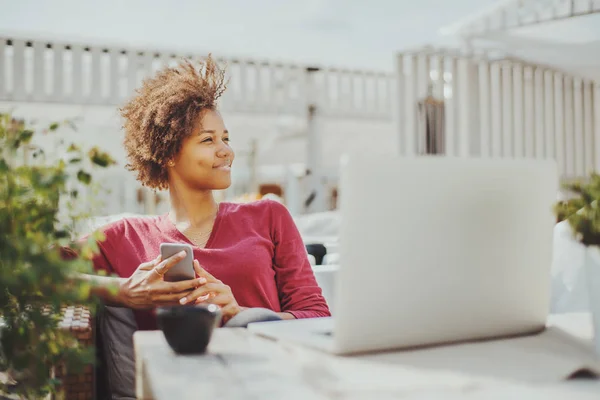 Kafede dizüstü bilgisayar ile siyah kıvırcık kız