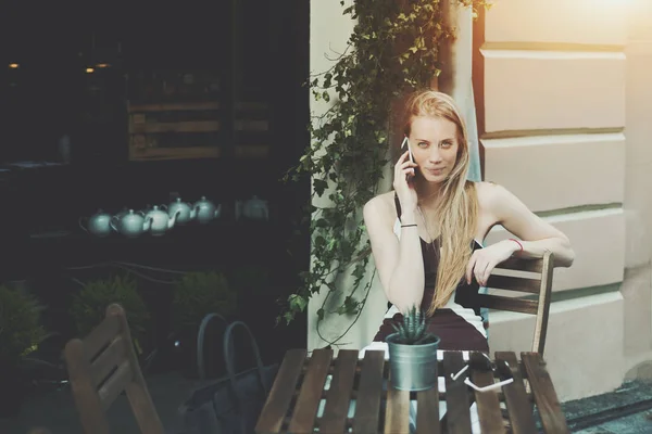 Привлекательная блондинка ждет свою подругу в уличном кафе — стоковое фото