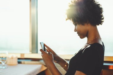 Sevimli siyah genç kadınla restoran ile smartphone