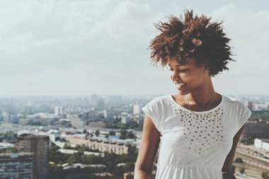 Balkonda biracial gülümseyen kıvırcık kadın genç