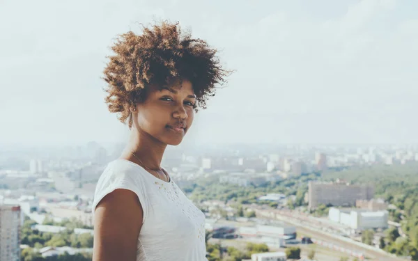 背景の街並みと魅力的な黒い女性 — ストック写真