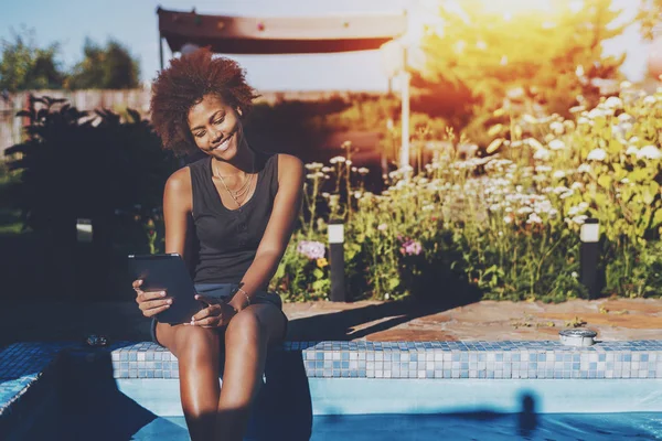 Chica brasileña cerca de la piscina con tableta digital — Foto de Stock