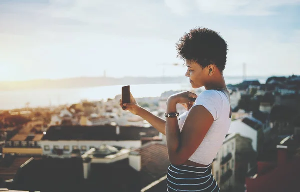 黒の女の子がバック グラウンドで都市景観と selfie を作っています。 — ストック写真