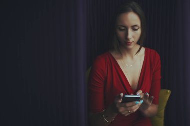 Office chillout içinde oturan smartphone ile Kırmızı elbiseli Bayan