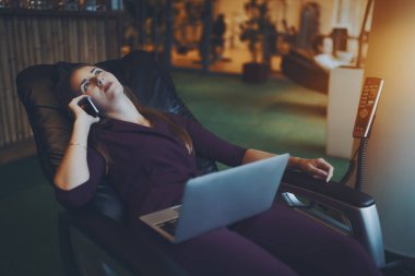 İş kadını kahve molası sırasında masaj koltuğu üzerinde yatıyor