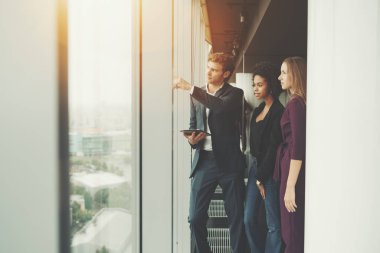 Üç iş adamlarını ofis pencere yakınındaki