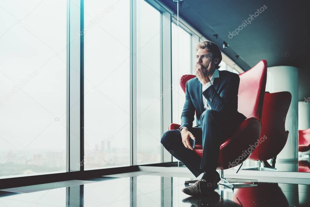 Vexed man entrepreneur on red chair