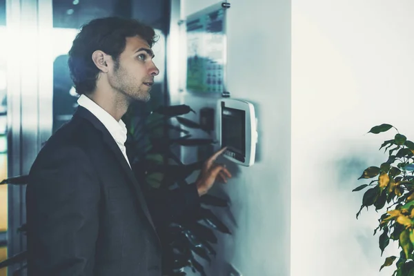 Hombre en la oficina usando terminal de control de luz —  Fotos de Stock