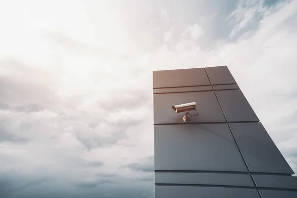 Kamera auf zeitgenössischer metallischer Wand und dramatischem Himmel dahinter — Stockfoto