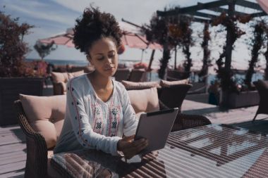 Kafede açık dijital tablet ile abanoz kadın 