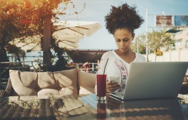 Dizüstü bilgisayar ve smartphone kafede Afrika Americal Bayan