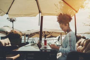 Dizüstü bilgisayar ve akıllı telefon nearshore çubuğunda Afro kız