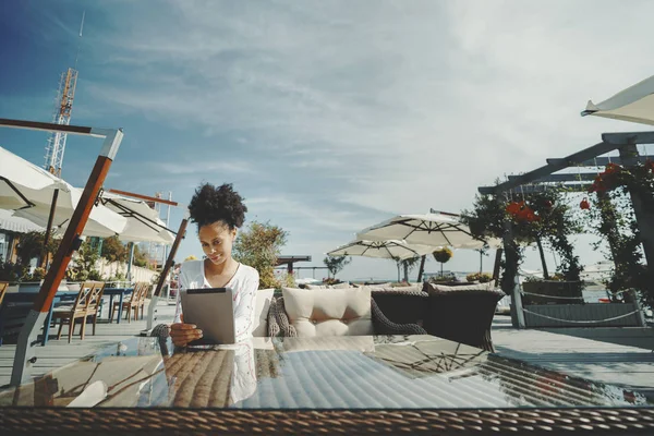 Menina afro no bar de rua com tablet digital — Fotografia de Stock