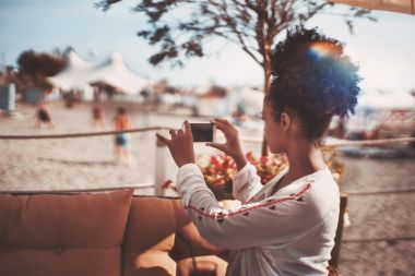 Afro kız Smartphone plaj sporları üzerinde çekim