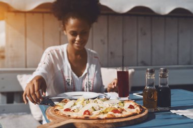 Afro kadın sokak kafede pizza yemek