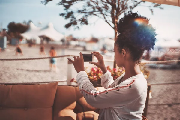 Afro chica tiro en smartphone playa deportes — Foto de Stock