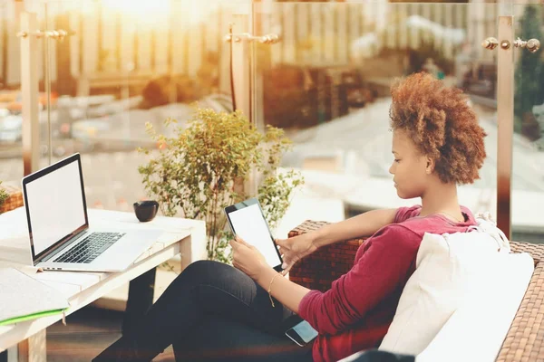 Mujer afro joven con almohadilla digital y portátil al aire libre — Foto de Stock