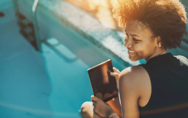 Ébano chica con digital tablet cerca de la piscina — Foto de Stock
