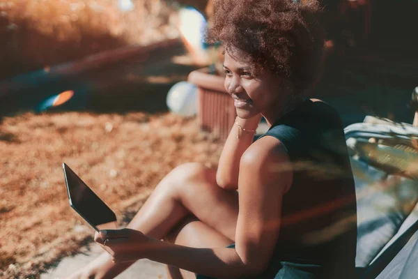 Afro chica en el jardín con tableta digital — Foto de Stock