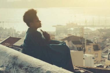Afro-Amerikan Kız çatıda sigara içiyor