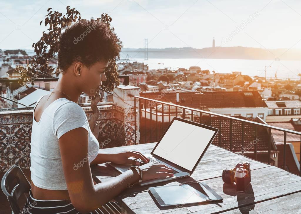 Black curly lady with laptop, digital pad and vintage camera