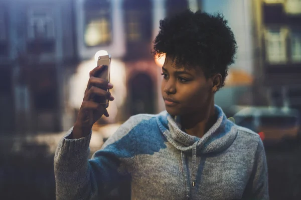 Ébano chica tomando foto en el teléfono celular en la noche —  Fotos de Stock