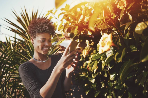 ブラジル女性は、公園の花の写真を撮る — ストック写真