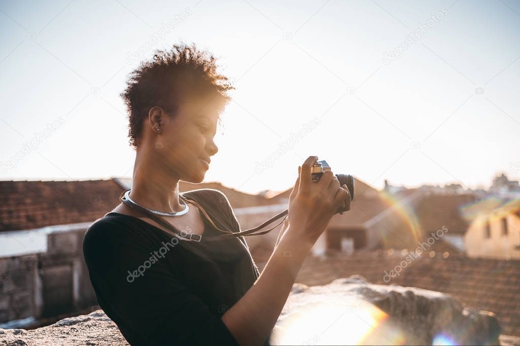 Black girl with retro camera on the roof