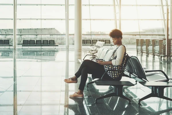 Menina preta usando smartphone na sala de espera do aeroporto — Fotografia de Stock