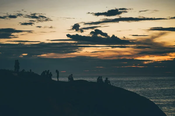 Coucher de soleil dramatique avec un groupe de personnes au bord de la mer — Photo