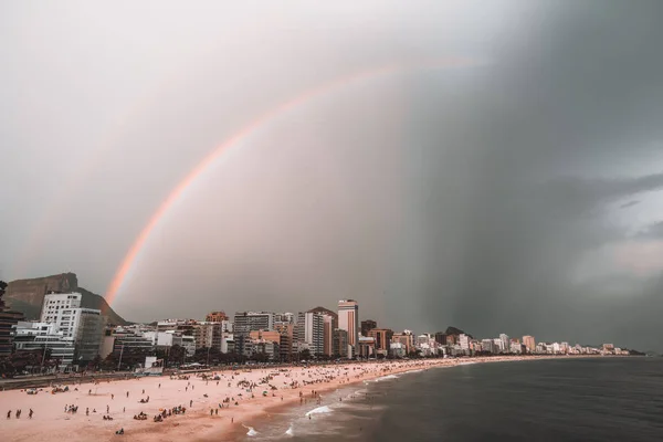 Céu tempestuoso com arco-íris sobre praia no Rio de Janeiro — Fotografia de Stock