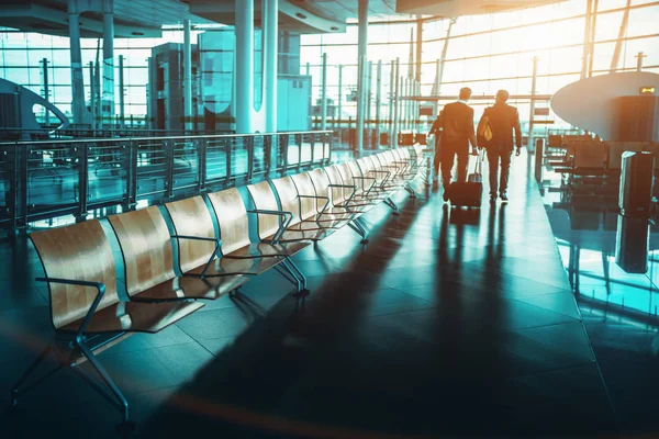 Silhouettes of two seniors with luggage indoors of railway stati — Stock Photo, Image