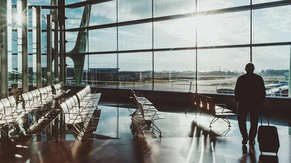 Man with luggage in airport terminal waiting hall