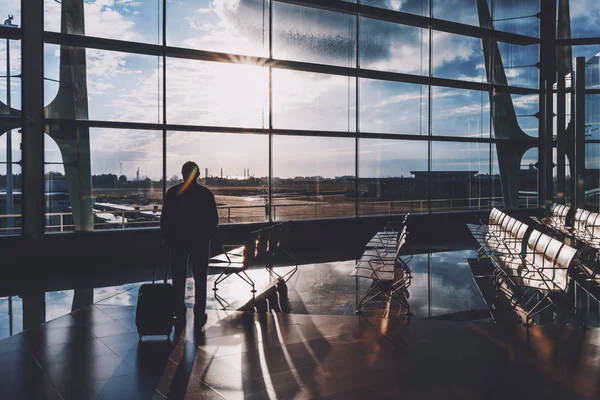 Silhouettes male tourist indoors of airport terminal