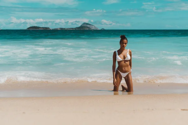 Gorąca czarna kobieta na plaży z widokiem na ocean za — Zdjęcie stockowe