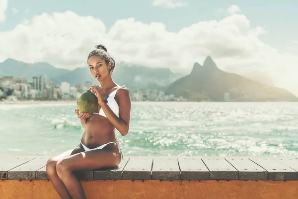 Beautiful Brazilian gril with coconut on the beach bench — Stock Photo, Image