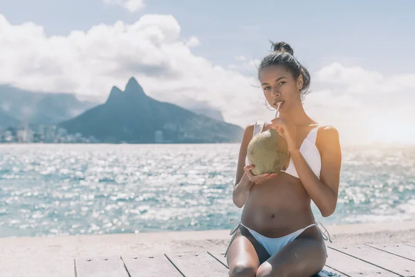 Afro American femmina sulla panchina da spiaggia con cocco — Foto Stock