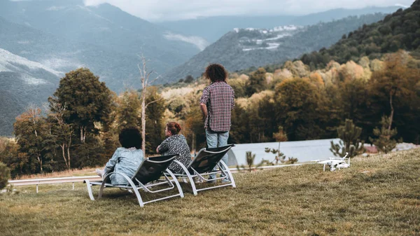 Gruppo di tre amici che osservano le terre dalla collina — Foto Stock