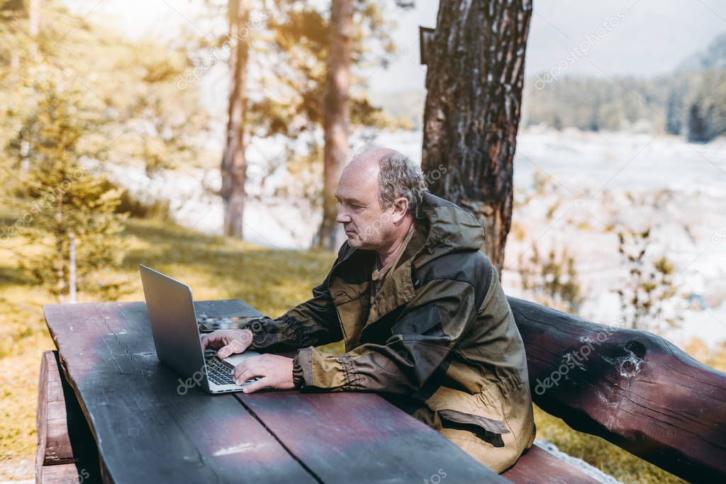 Businessman with laptop during his vacations in forest