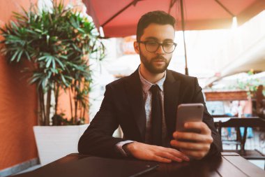 Cep telefonu ile sokak restoranda adam girişimci