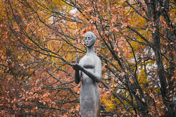 Bronze sculpture of mournful woman holding burning candle — Stock Photo, Image