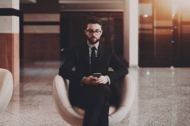 İşadamı ile ofis koltuk içinde smartphone