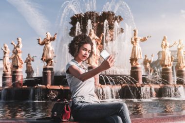 Siyah kız kendini bir çeşme önünde fotoğraf çekimi