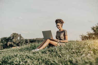 Brezilyalı kadın, çim üstünde laptop