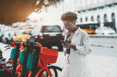 Siyah kız e-scooter 'ı çalıştırıyor.