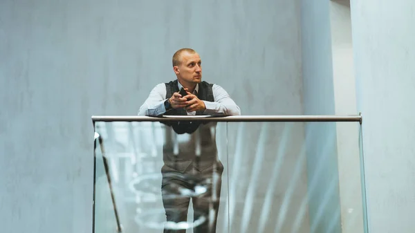 Бизнесмен на стеклянном балконе — стоковое фото
