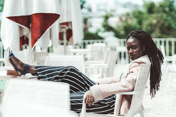 Menina em um bar com os pés na mesa — Fotografia de Stock