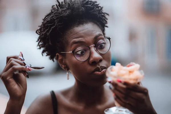 Svart flicka äter en dessert utanför — Stockfoto