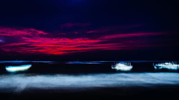 boats in ocean at night