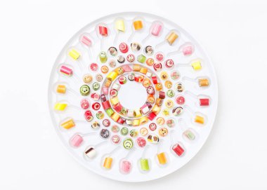 Beyaz plaka üzerinde renkli lolipop